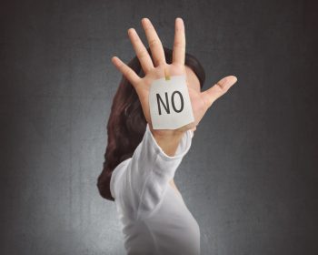 Side view of woman showing NO note on her hand