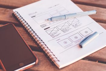 An image showing a UX Designer’s notepad with some hand-drawn wireframes